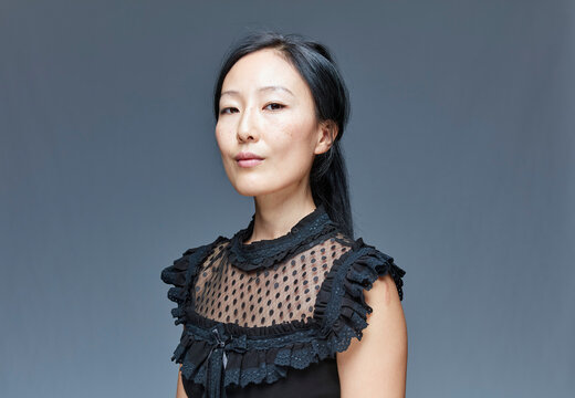 Portrait of self-confident woman in front of grey background