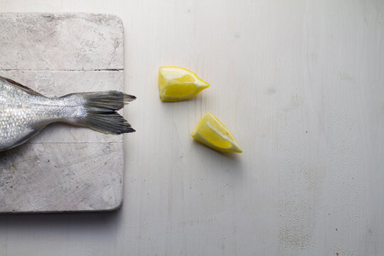 Fish tail with lemon on table, close up
