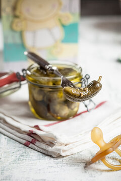 Pickled cornichons in preserving jar, fork and dummy