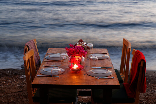 Turkey, Bodrum, Guemuesluek, Laid table on beach at dusk