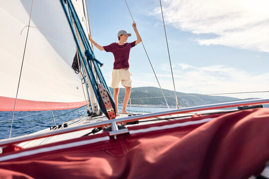 Teenage boy standing on a sailboat in the Adriatic Sea in Croatia