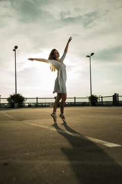 Young ballet dancer exercising on a parking level