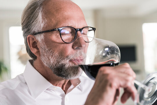 Portrait of mature man drinking glass of red wine