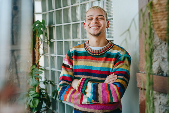 Smiling businessman wears a striped sweater in the modern office