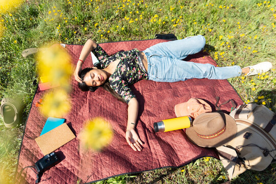 A woman enjoys outdoor relaxation while sunbathing in a meadow