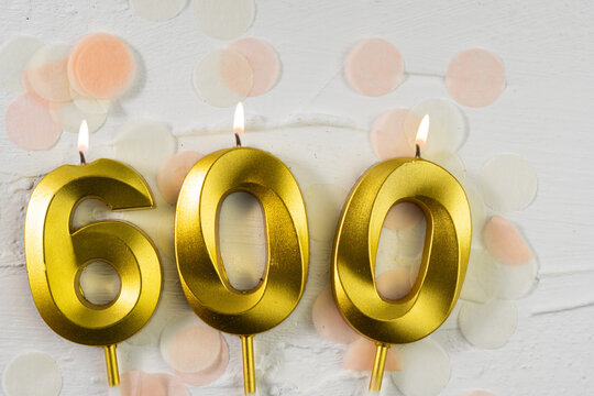 600 followers or subscribers. card golden birthday candle six hundred on confetti background. Template for social networks, community fans.