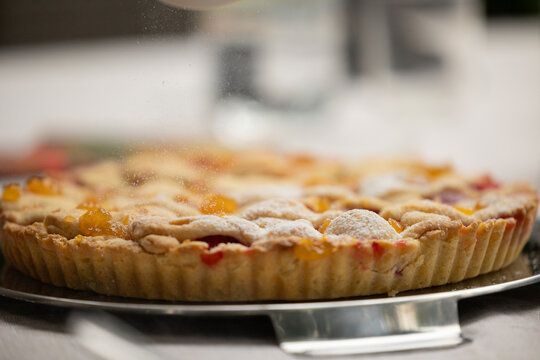 crostata dolce fatta in casa con pezzi di pesche e fragole vista di profilo
