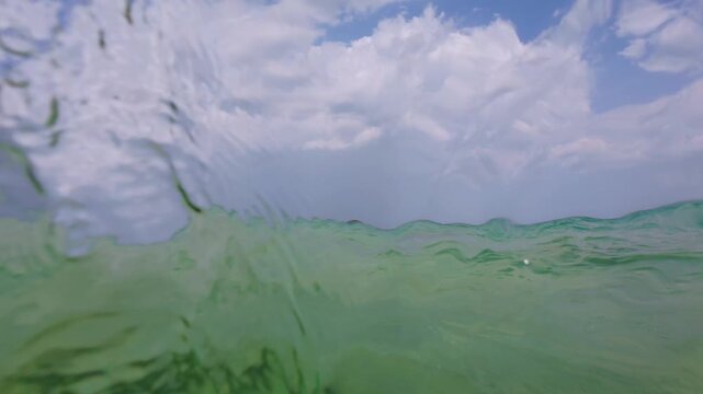 Slow Motion Split View Sea Water Surface Waves and Cloudy Sky