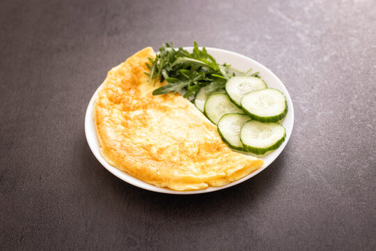Omelette with cucumber slices and herbs on a plate