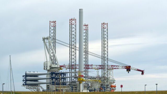 Esbjerg, Denmark - 31 July 2026: View of the Wind Keeper offshore vessel transporting wind turbine blades and a tower section while sailing through the water near the marina.