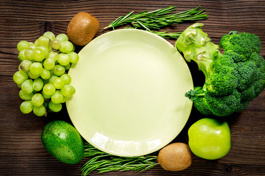 green fresh vegetables and fruits for healthy salad on wooden table background top view mockup