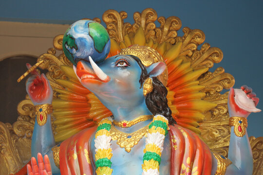 Close-up portrait of Hindu god Varaha avatar of Vishnu lifting the Earth on his tusks inside a temple.