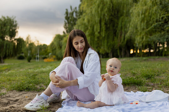 Mother and baby enjoying a peaceful moment together on a blanket outdoors