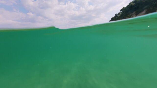 Slow Motion Split View Rocky Sea Coast and Emerald Water