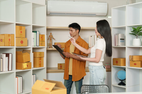 Asian small business owners managing parcel inventory for online store fulfillment