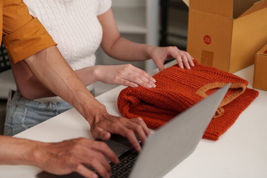Small business owner typing on laptop to manage online store orders with AI technology and automation