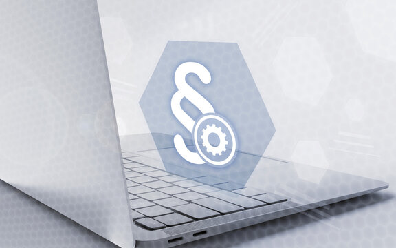 A laptop keyboard paired with a glowing legal paragraph symbol and a gear icon, symbolizing digital law, software settings, compliance technology, and modern legal tech solutions.