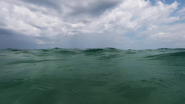 Slow Motion Split View Sea Water Surface Waves and Cloudy Sky