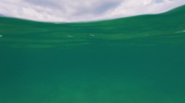 Slow Motion Split View Sea Water Surface Waves and Cloudy Sky