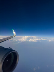 Fototapeta premium Airplane Wing and Jet Engine Above the Clouds