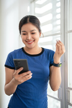 Fitness woman with earphones listening to music after workout.