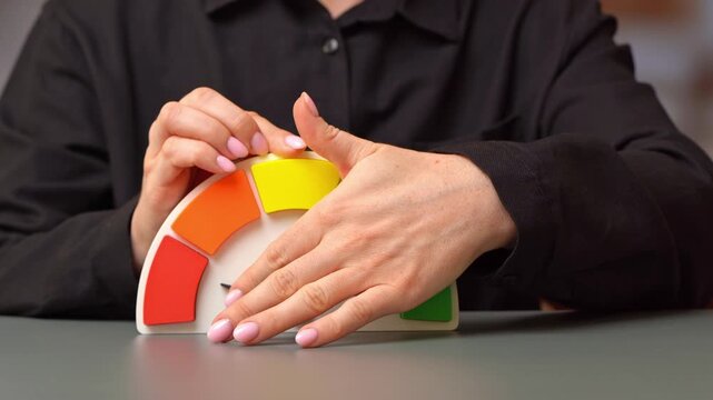 The woman turns the rating arrow to the red sector. Low rating, worst performance. Low efficiency and terrible productivity with financial losses and urgent turnaround strategy.