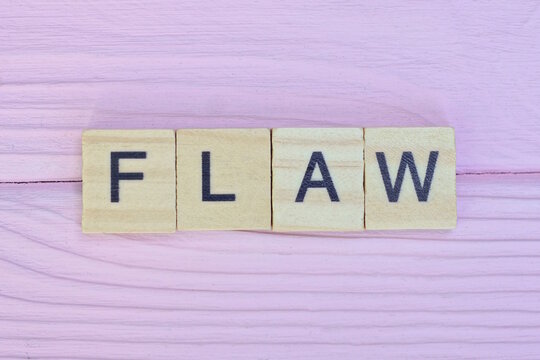  word flaw from gray wooden small letters with black font on an pink background

