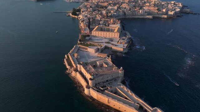 Syracuse, Italy. Aerial of Ancient city on Sicily island, Maniace Castle surrounded by Mediterranean Sea at Sunset.