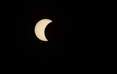 Solar eclipse phase on August 12, 2026, captured in Portugal. Thin crescent of the sun isolated on a black sky background. A rare astronomical celestial event shot © volff