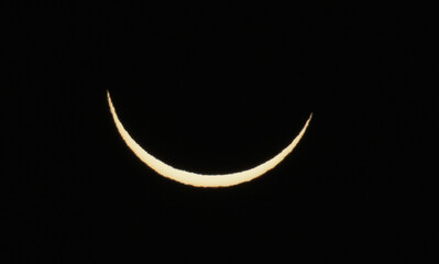 Solar eclipse phase on August 12, 2026, captured in Portugal. Thin crescent of the sun isolated on a black sky background. A rare astronomical celestial event shot © volff