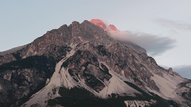 Drone close-up of Monte Antelao illuminated by warm sunset light above San Vito di Cadore in the heart of the Dolomites, Italy