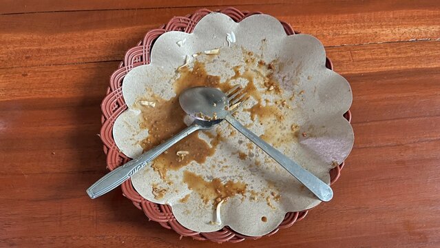 Dirty restaurant plate with crossed cutlery after customer finished eating