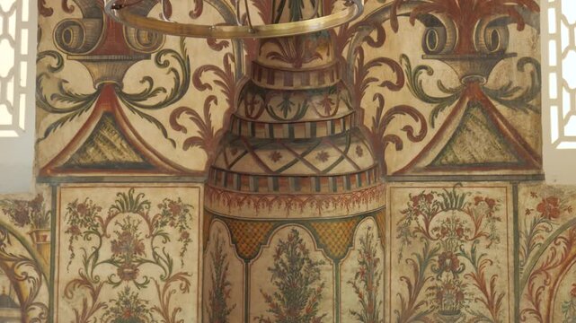 Ornate floral wall paintings and a vintage pendulum clock inside Et'hem Bej Mosque with slow camera move