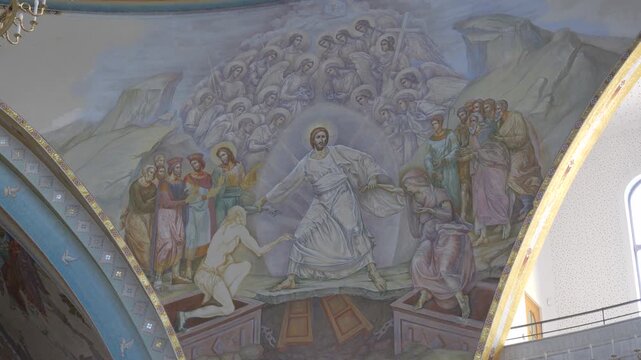 Camera tilts across a large dome fresco of Christ&rsquo;s Resurrection inside the Orthodox cathedral in Tirana, Albania