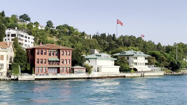 Scenic view of traditional wooden waterfront mansion houses Yali on the Bosporus strait coastline under a blue sky in Istanbul, Turkey