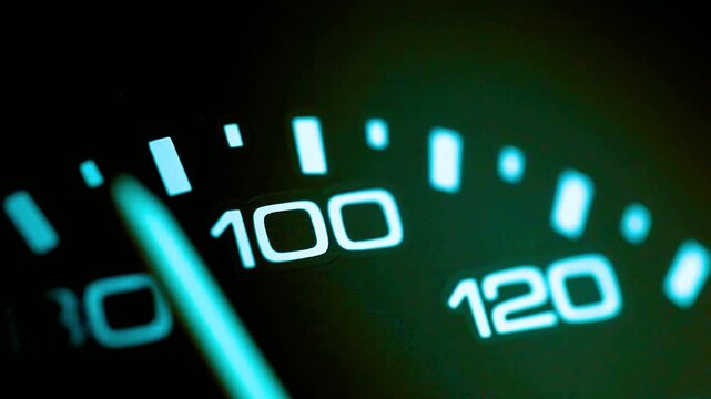 closeup of car speedometer needle moving quickly past one hundred, representing high speed, acceleration, automotive performance, racing, danger, travel