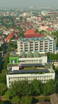 Urban building with rooftop solar panels across Yogyakarta skyline