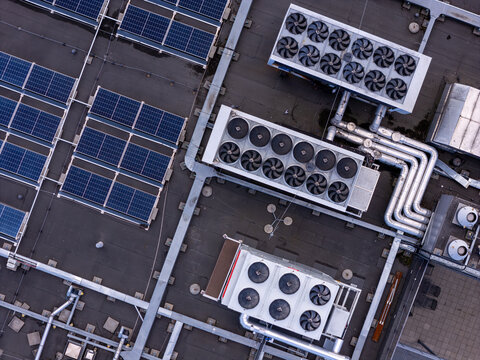 Aerial view of a data center rooftop featuring solar panels and industrial HVAC cooling units in Gdansk, Poland.