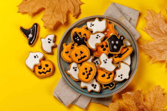 Halloween gingerbread cookies on bright yellow background