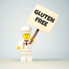 Fototapeta premium Indonesia - June 1, 2026 : Mini toy of action figure with blur background. Miniature photography concept design. Minifigure of people character hold GLUTEN FREE message text at poster banner.