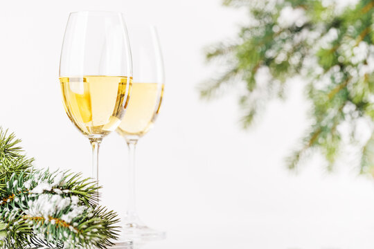 Champagne glasses and snowy fir on white