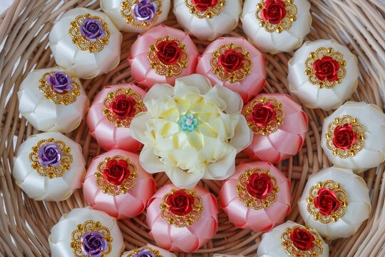 Handmade craft Thai festival decoration,Coins wrapped in floral ribbons on a basket against   background.
