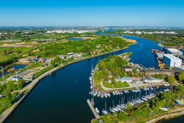 Aerial view of Górki Zachodnie and the Martwa Wisła in Gdańsk, Poland, with marinas, sailboats, industrial areas and lush coastal landscape. © Kamil