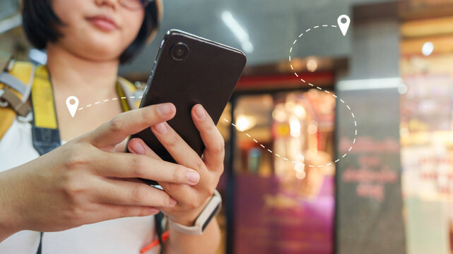 Asian woman using smartphone navigation app for travel direction and route location