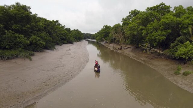 Khulna, Bangladesh &ndash; March 20, 2025: Local Fishermen Rowing Wooden Boats Through Sundarbans Mangrove Forest