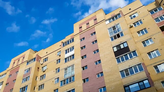 Brick apartment building. Apartment in the city, in a residential neighborhood. Apartment building with windows and a balcony; affordable housing.