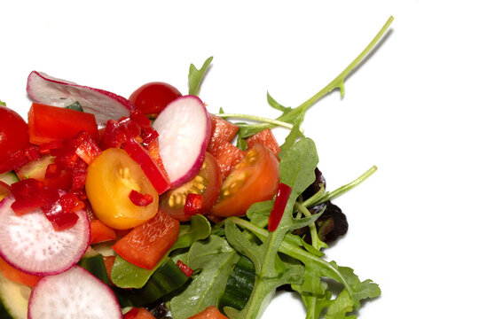 Close up of a delicious healthy side salad with leaves and radish on a white plate