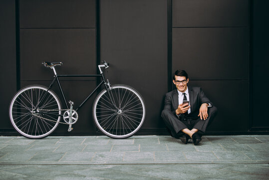 Young handsome man with business suit driving bicicyle to go to office - Corporate businessman portrait biking in the city, concepts about business, green mobility and lifestyle