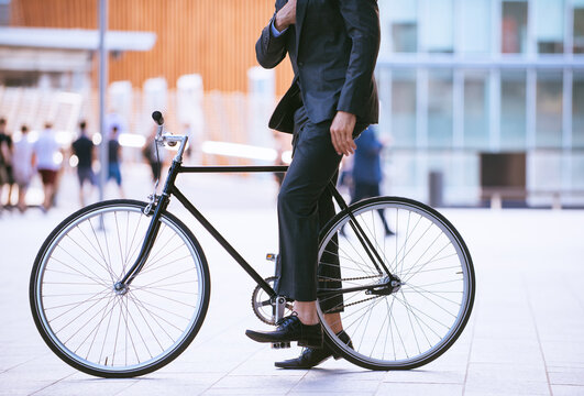 Young handsome man with business suit driving bicicyle to go to office - Corporate businessman portrait biking in the city, concepts about business, green mobility and lifestyle