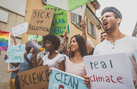 Public demonstration on the street against global warming and pollution. Group of multiethnic people making protest about climate change and plastic problems in the oceans